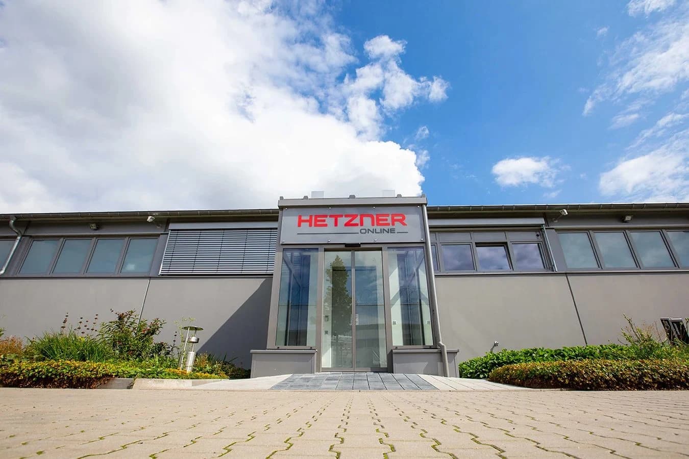 Building entrance with a Hetzner Online sign and landscaped forecourt