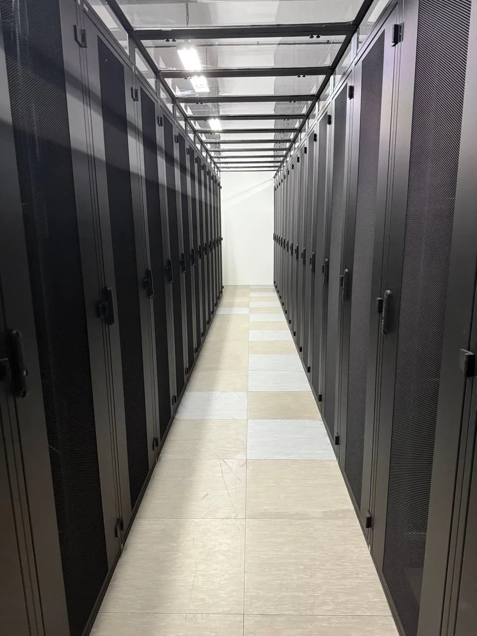 Server aisle at firstcolo FRA4 with two rows of enclosed server cabinets