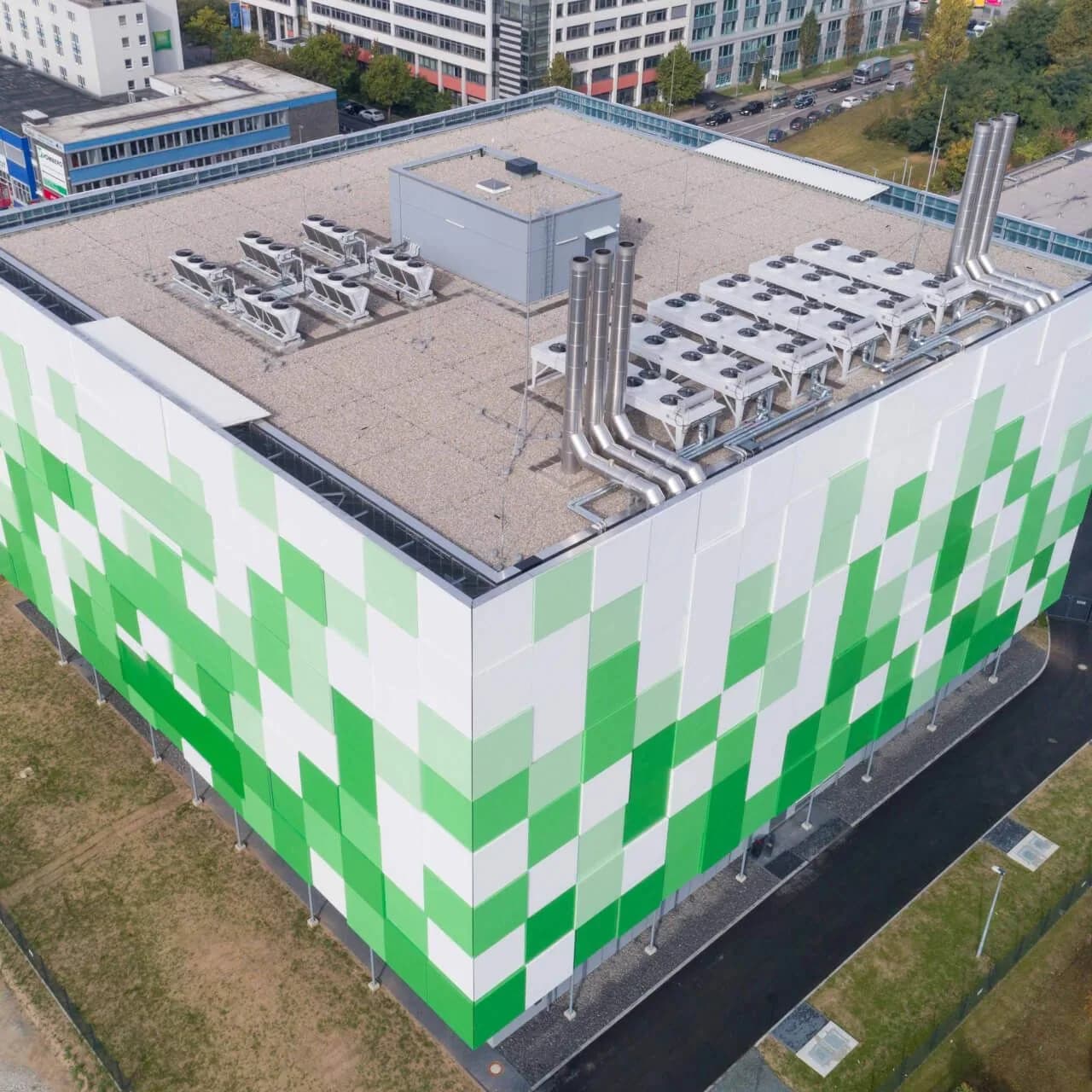 Aerial view of maincubes FRA01 with its green and white facade and rooftop cooling equipment
