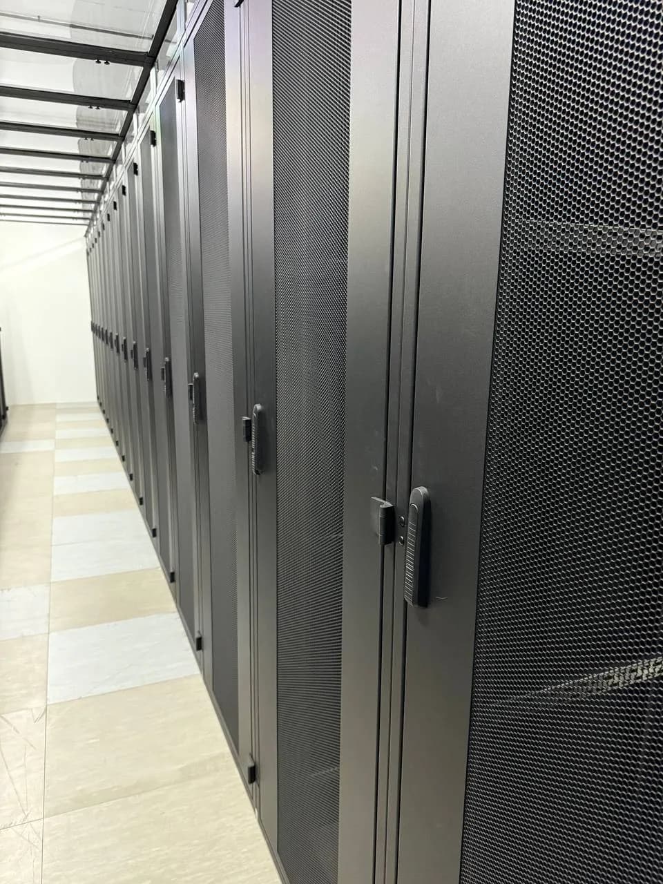 Reihe geschlossener Serverschränke mit perforierten Türen im firstcolo FRA4